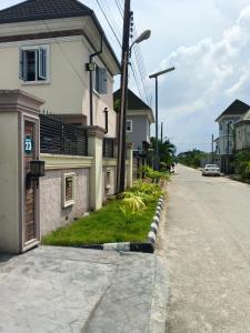 une rue vide à côté d'une maison avec un lampadaire dans l'établissement Brandison Apartments, à Port Harcourt