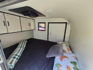 伊塔蒂巴Quinta do Vale - Mini-trailer: caiaque, lago, standup, cascata, piscina的小房间,带拖车床