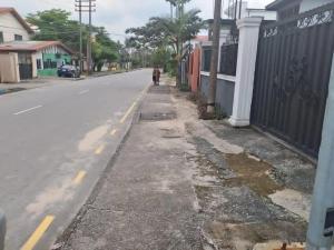 an empty street with a person walking down the road at B&L Apartments in Port Harcourt