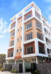 un alto edificio bianco e arancione con finestre di Axon Corporate Stays Newtown, Kolkata a kolkata