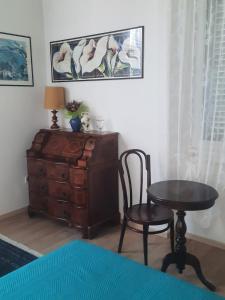a room with a table and a chair and a dresser at Il Gelsomino "Meraviglioso appartamento in villa Liberty" in Gorizia