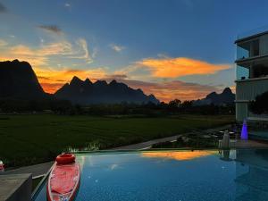 a swimming pool with a boat next to a building at Paddy Fields Resort-Guilin Shuidaotian in Yangshuo