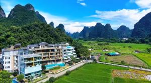 une vue aérienne d'une station balnéaire avec des montagnes en arrière-plan dans l'établissement Yangshuo County Rice Field Resort Hotel, à Yangshuo