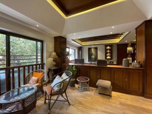 a room with a balcony with chairs and a table at Ambassador Garden Home in Kathmandu