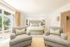 a bedroom with a bed and two chairs at Last Word Constantia in Cape Town +46 photos