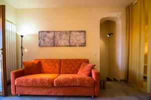 eine orangefarbene Couch im Wohnzimmer in der Unterkunft Ferienwohnung Stella in Alberese