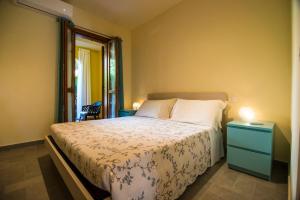 ein Schlafzimmer mit einem Bett mit blauem Nachttisch und einem Fenster in der Unterkunft Ferienwohnung Stella in Alberese