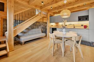 a dining room with a table and a couch at Chalet na vrchoch in Nesluša