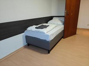 a small bed in a room with a wooden floor at Fmi35 in Rüsselsheim +7 photos