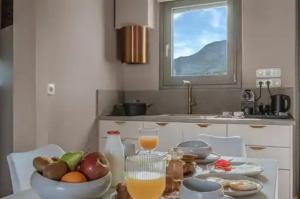 Eine Küche mit einem Tisch, auf dem eine Schale mit Obst und Orangensaft steht. in der Unterkunft Locanda in Monemvasia + 45 Fotos