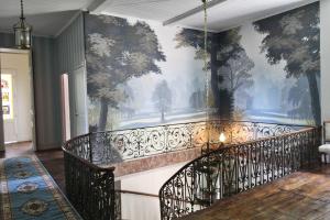 a staircase with a mural of trees on a wall at Dordogne Chateau with Pool & Garden Sleeps 14 villa in Bourdeilles
