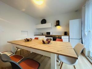 a kitchen and dining room with a wooden table and chairs at Casa Les Ponts de Cé in Les Ponts-de-Cé