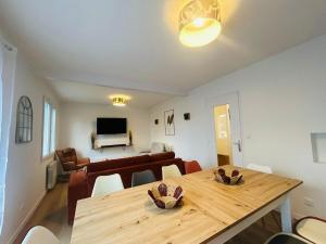 a dining room and living room with a wooden table at Casa Les Ponts de Cé in Les Ponts-de-Cé