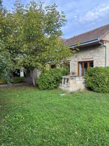 a brick house with a tree in the yard at Úrágya Vendégház in Mád