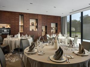 科尔马L'Esquisse Hotel & Spa Colmar - MGallery Collection的配有餐桌、餐具和玻璃杯的餐厅