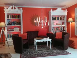 a living room with red walls and a couch and a table at Ferienhaus Lavendel in Gensac