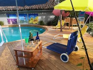 a pool with a table and a cart with wine bottles at Ferienhaus Lavendel in Gensac