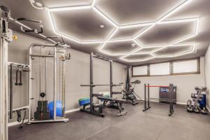 a fitness room with a gym with tread machines at Hotel Villa Lago in Bad Wiessee