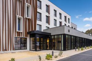 un bâtiment de bureau avec une façade noire et blanche dans l'établissement Campanile PRIME - Smart Lyon Chaponost, à Chaponost