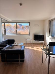 un salon avec un canapé et une télévision dans l'établissement MAVO Hospitality Esslingen Berliner Straße, à Esslingen am Neckar