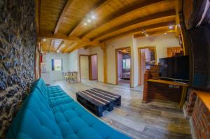 Una sala de estar con un sofá azul y un televisor. en Camping Playa de Ajo, en Ajo