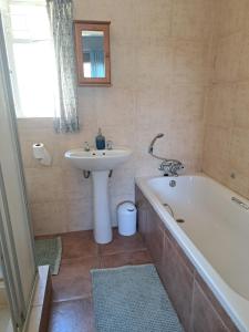 a bathroom with a sink and a bath tub and a sink at Susanna's Self catering 2 bedroom apartment in Kimberley +10 photos