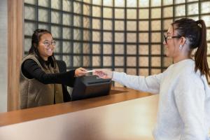 deux femmes debout à une table tenant une télécommande Wii dans l'établissement Campanile PRIME - Smart Lyon Chaponost, à Chaponost