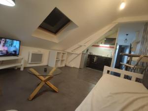a living room with a couch and a table and a tv at TOK TOK A5 Appartement 1Ch Proche toutes commodités in Annoeullin