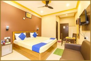 une chambre avec un lit, une télévision et un canapé dans l'établissement Sayan Lane Road Manshree Palace Resort- Fully Air Conditioning Room# Prime Location# Fully Air Conditioning Room# Prime Location# Parking And Free Wifi- Premium Best Hotel In puri, à Purî