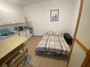 une petite chambre avec un lit et une cuisine dans l'établissement Le pied du Beffroi d'Arras, à Arras