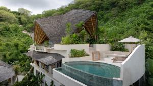 an aerial view of a house with a swimming pool at Mambo Lombok in Kuta Lombok