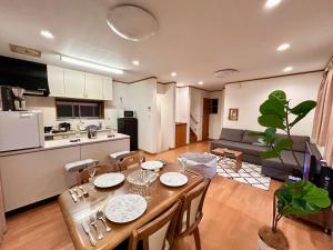 una cucina e un soggiorno con tavolo e sedie di AiES新小岩 新小岩站走8分 繁华商店街旁 最大12人 直达机场秋叶原新宿 旅馆内带免费停车场庭院露台 邻公园 a Tokyo