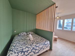 une chambre avec un lit dans une pièce verte dans l'établissement L'Oradou #Parking#Terrasse, à Clermont-Ferrand