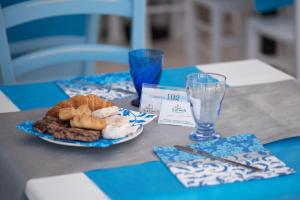 ein Tisch mit einem Teller Brot und einem Glas Wasser in der Unterkunft The Twin Boutique Hotel in Torre Suda