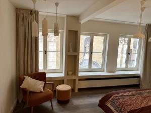 a bedroom with a bed and a chair and windows at guesthouse 't Kleihuys in Bruges +71 photos