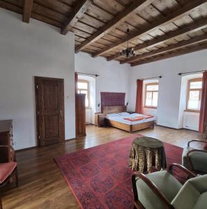 a large room with a bed and a rug at Úrágya Vendégház in Mád