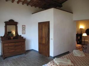 a bedroom with a bed and a dresser and a mirror at Appartamento Rosso in San Donato in Poggio