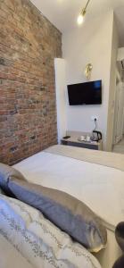 克拉科夫Kazimierz Residence Square的一间卧室，有一张白色的床和一面砖墙