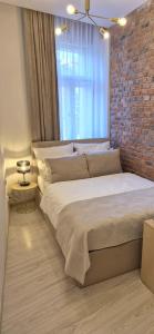 克拉科夫Kazimierz Residence Square的一间卧室，配有一张大床和砖墙