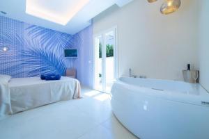 ein weißes Bad mit einer Badewanne und einem Tisch in der Unterkunft The Twin Boutique Hotel in Torre Suda + 61 Fotos