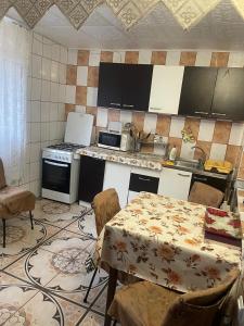 Una cocina con una mesa con sillas y una estufa. en Vila Movila Revelion 2026, en Azuga