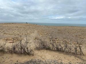 洛肯6 person holiday home in Løkken-By Traum的阴天有岩石和海洋的海滩