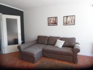 - un salon avec un canapé brun et deux photos sur le mur dans l'établissement Ferienhaus Mit Garten Und Stellplatz, à Großenaspe