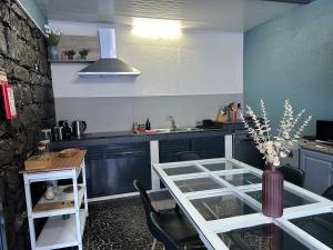 eine Küche mit blauen Schränken und einem Tisch mit einer Vase in der Unterkunft Quiet Place in Machico