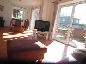 Il comprend un salon doté d'une télévision à écran plat et d'un balcon. dans l'établissement Ferienhaus Mit Garten Und Stellplatz, à Großenaspe