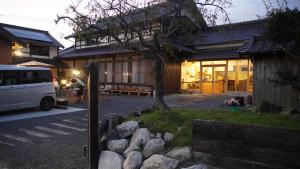 uma casa com uma carrinha estacionada em frente em 旅籠屋cafeKATARI em Karatsu