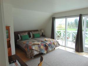 a bedroom with a bed and a balcony at Dutchies-dk in Væggerløse