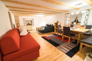Haus Lucas Tschofen في Aussergosten: غرفة معيشة مع أريكة حمراء وطاولة