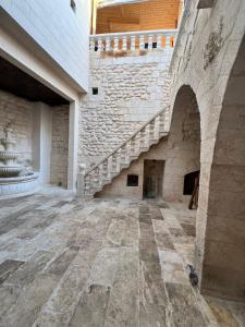 an empty room with a staircase in a stone building at Diib House Hotel in Urfa +44 photos