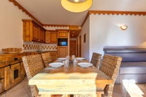 尚帕尼恩瓦努瓦茲Pralioud – Confort moderne, spa & piscine的配有木桌椅的餐厅